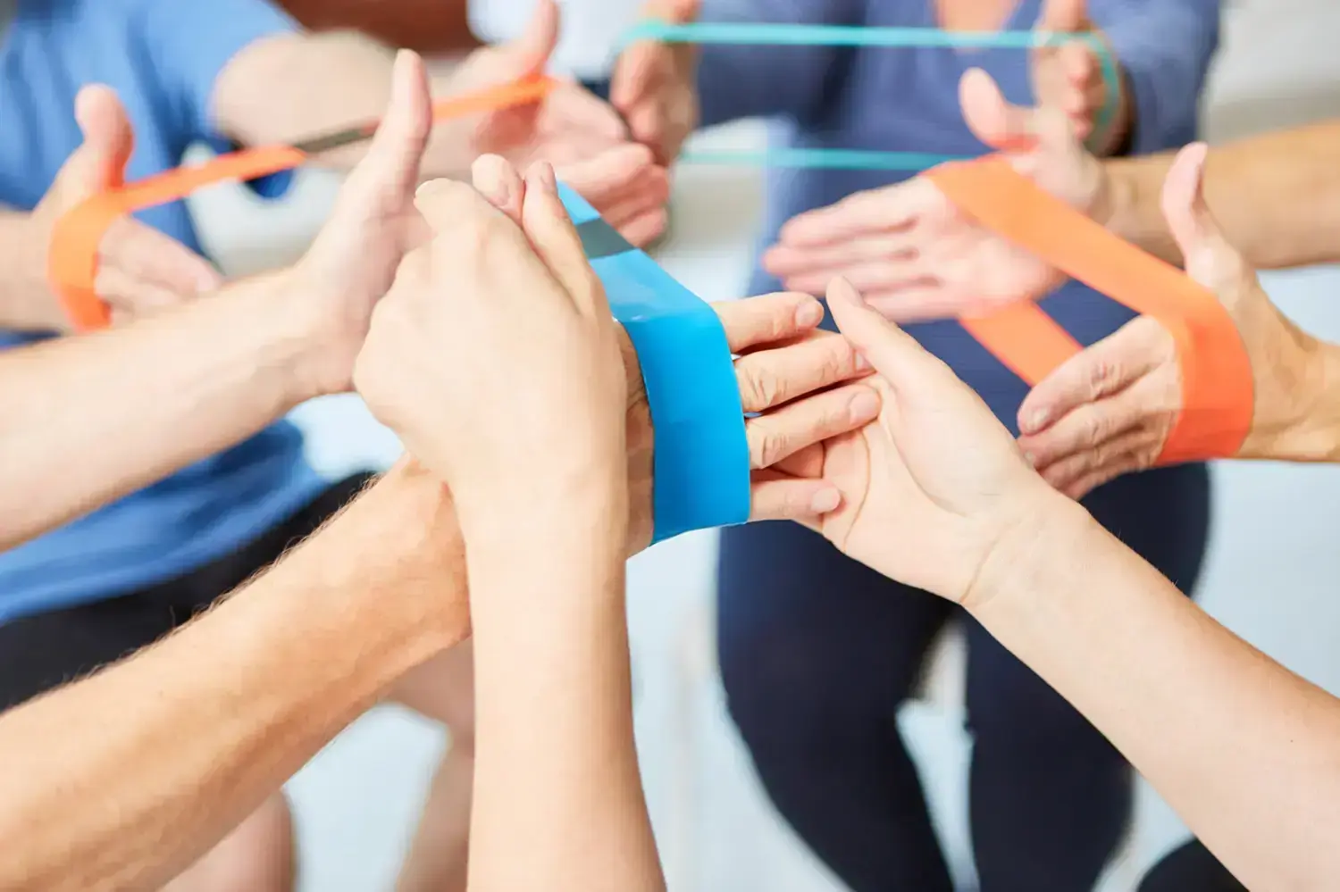 Gesundheitszentrum Werth - Physiotherapie und medizinische Behandlungen - Trainer hilft bei Übung mit dem Elastikband